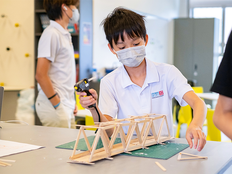 Self-directed learning at Hong Kong Academy - student constructing a wooden bridge
